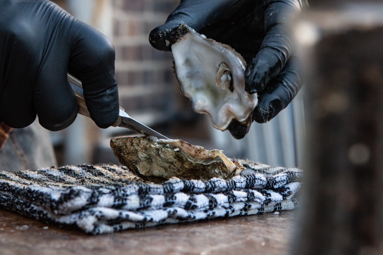 A person breaking the shell of an oyster